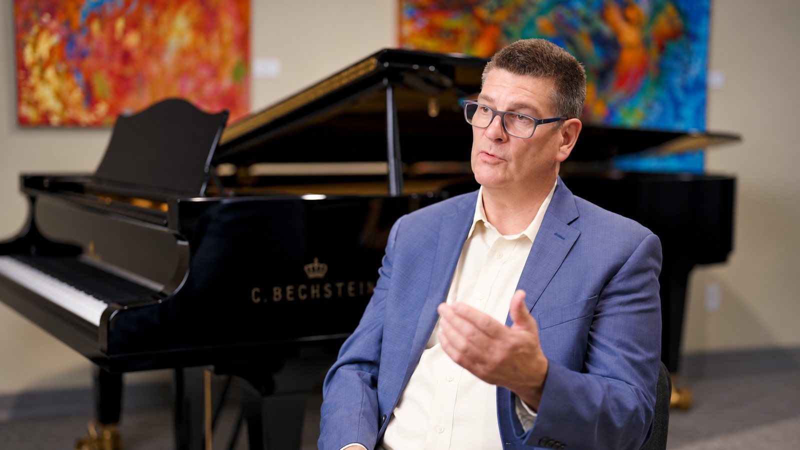 Business owner interviewed beside a grand piano for a brand video