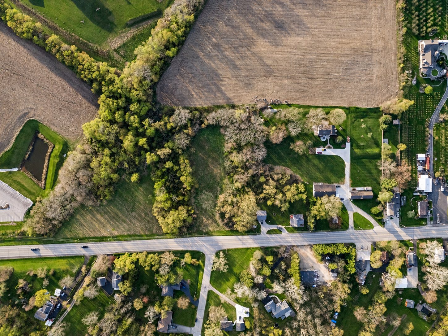 Top-down aerial of farmland, woods and homes in Southeastern Wisconsin for a land listing