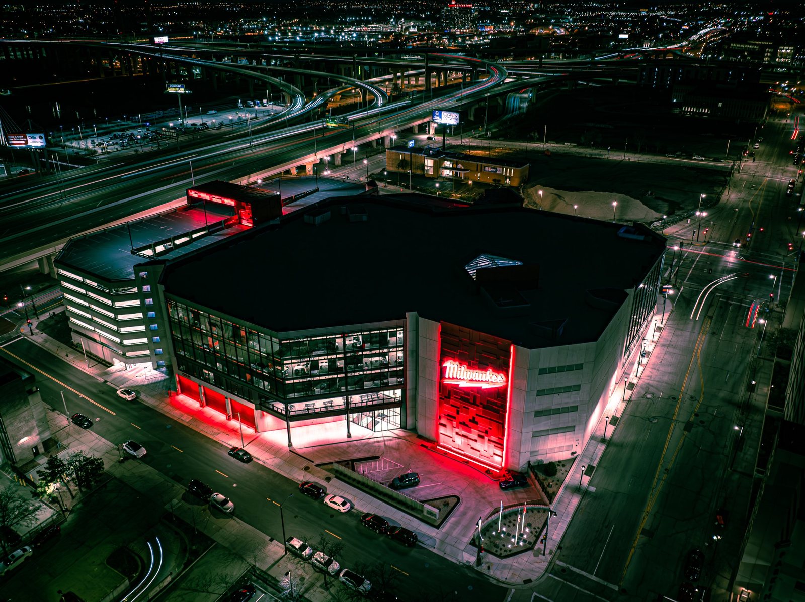 Night aerial of a downtown Milwaukee building and the Marquette Interchange, drone photo by Bokeh Film Production